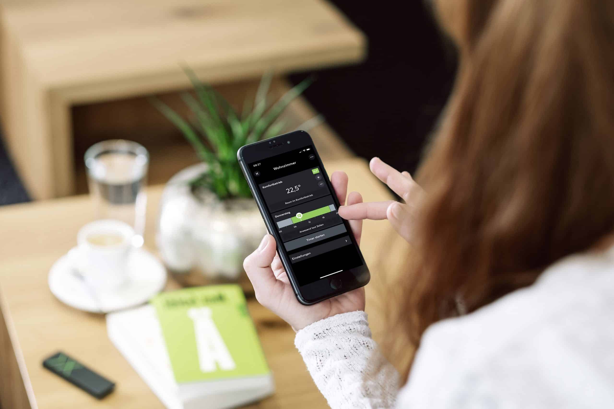 Frau mit SmartPhone im Smarten zu Hause mit Technik von Loxone. Bild zeigt die moderne Gebäudetechnik.